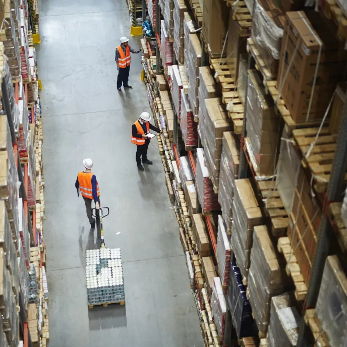 Trabajadores en un almacén logístico, reflejando la eficiencia en la cadena de suministro.